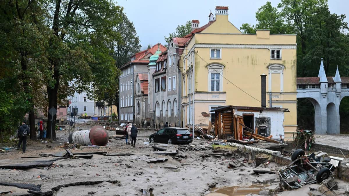 Люди идут по затопленным улицам после сильных ливней в курортном городе Ладек-Здрой на юго-западе Польши, 15 сентября 2024 года. Фото: Maciej Kulczynski / EPA-EFE