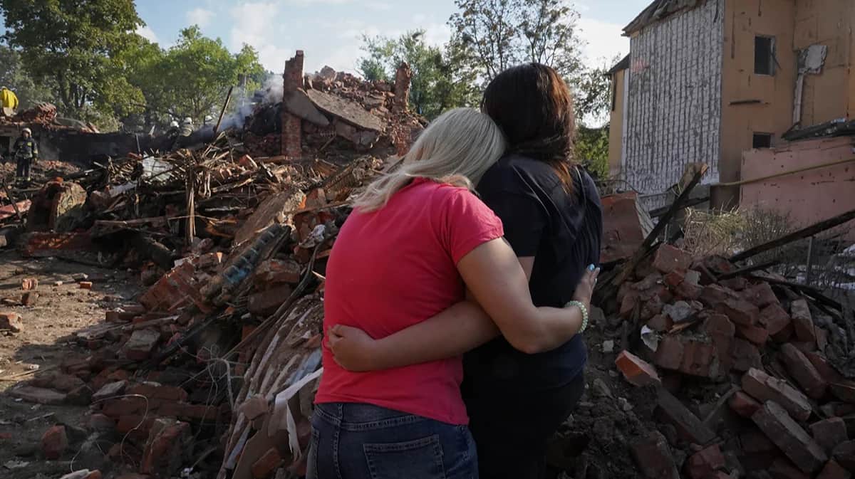 Украинские женщины у дома, разрушенного во время ракетного удара, в Харькове, Украина, 18 августа 2022 года. Фото: Андрей Мариенко / AP / Scanpix / LETA